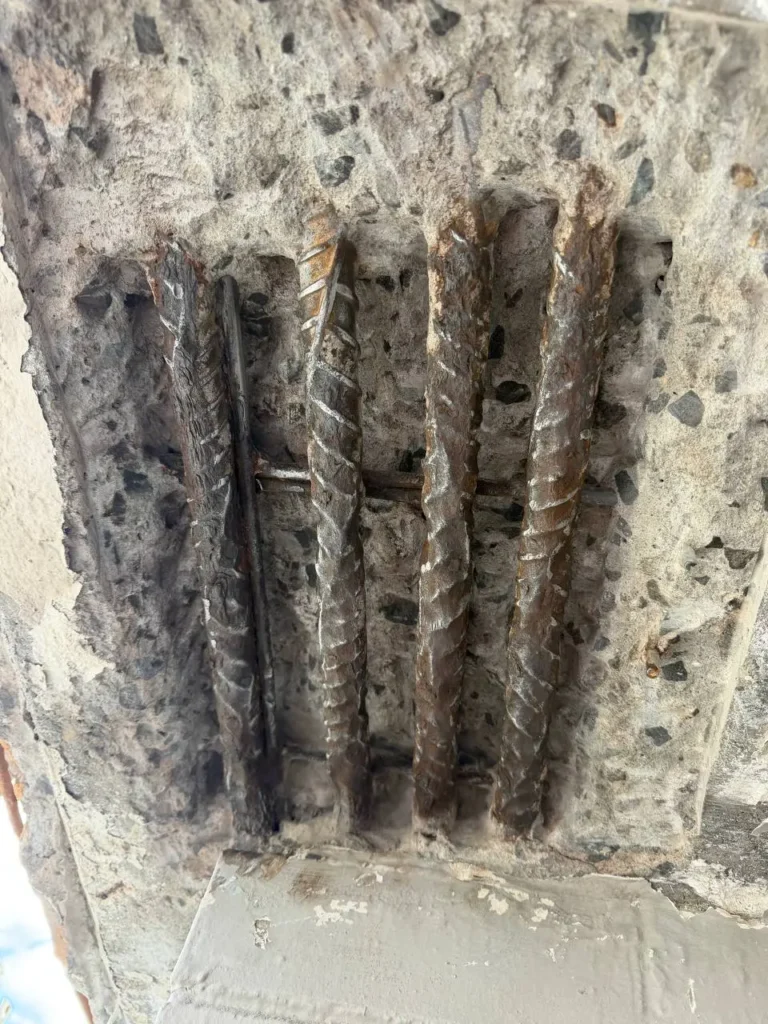 Expert concrete repair and concrete cancer treatment showing exposed steel reinforcement bars in Melbourne CBD by EQ Painting Solutions.