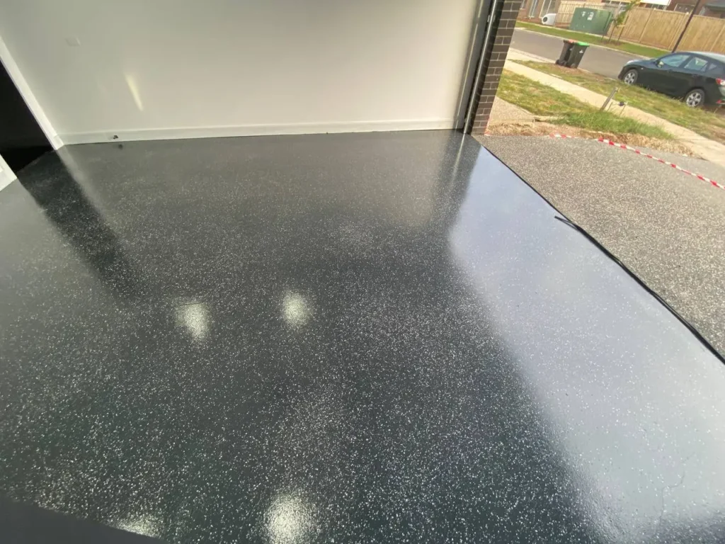 Glossy black epoxy garage floor with decorative flake finish installed by professional epoxy flooring specialists in Melbourne.